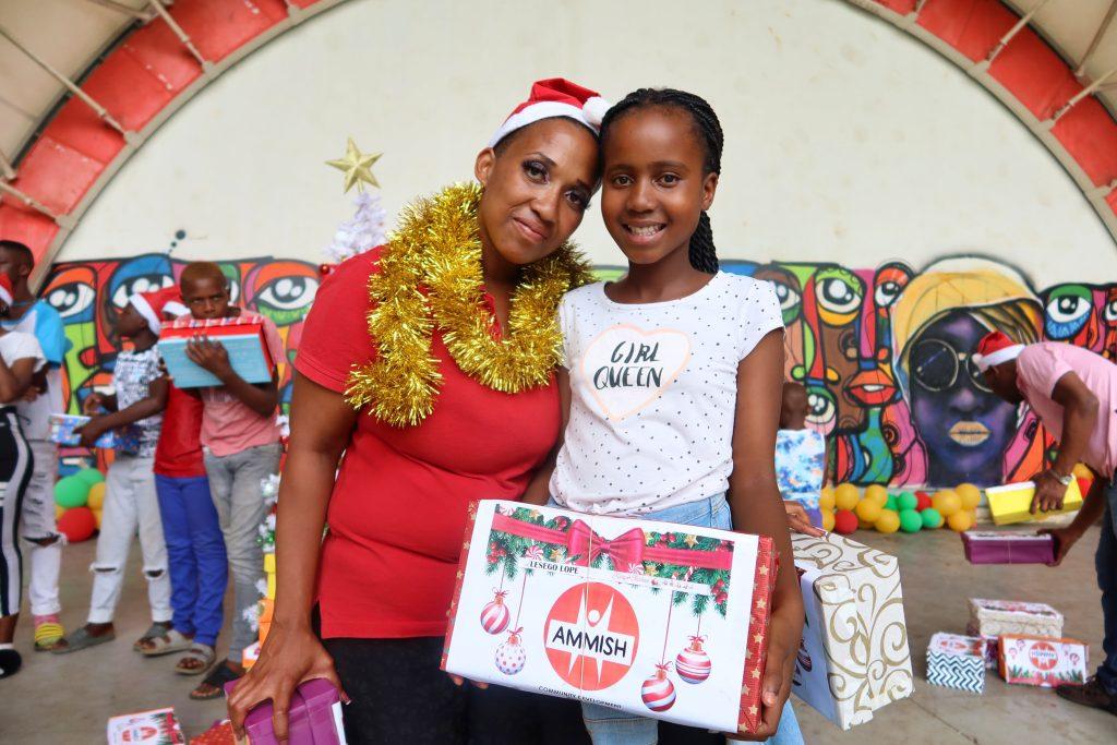 A woman and a girl with a shoebox full of presents.
